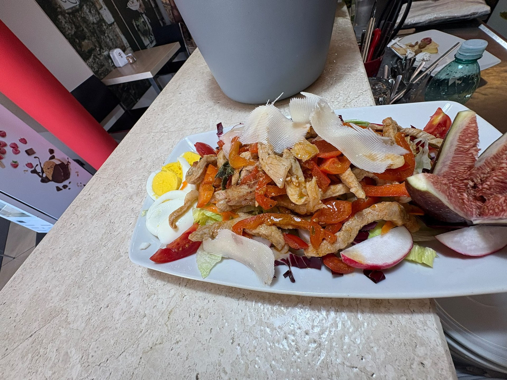 Insalata Dolce Aroma con straccetti, peperoni, scaglie di formaggio, uovo sodo, ravanelli e fichi su piatto bianco
